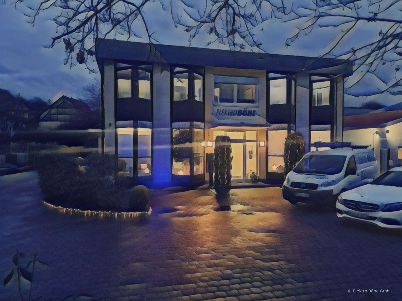 Das Firmengebäude der Elektro Böhe GmbH am Abend, beleuchtet, mit Firmenfahrzeug